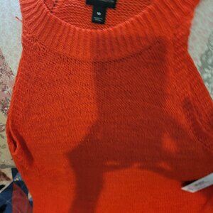 Sleevless knitted bright orange sweater.